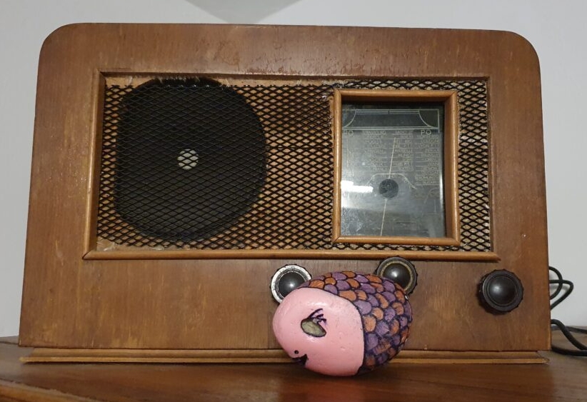 Galet "Miss PoissonChat" déposé devant une vieille radio TSF"